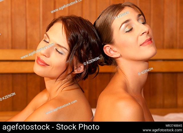 Two female friends in a sauna doing wellness in a Spa and obviously enjoy it