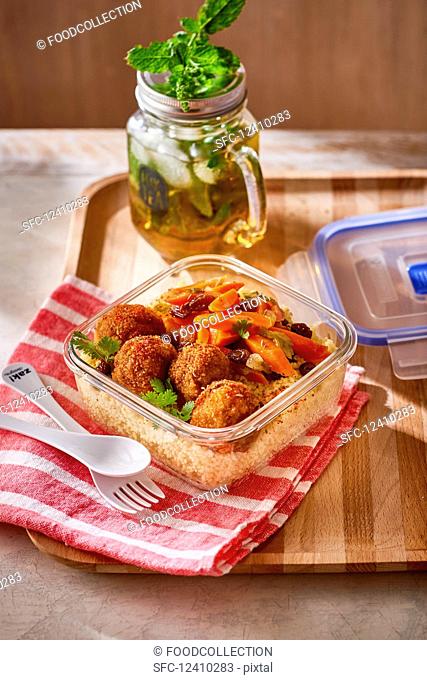 Lamb meatballs with vegetables on couscous in a tupperware box