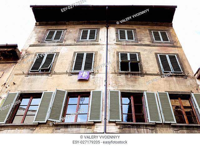 travel to Italy - facade of old house with pennant with the coat of arms of Florence in Florence city