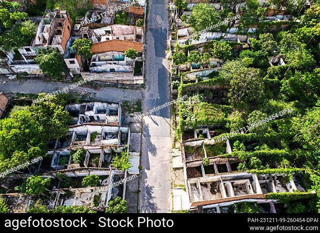 11 December 2023, Brazil, Maceio: A man walks past abandoned houses in the Bebedouro district, which was evacuated due to the risk of collapse at a salt mine