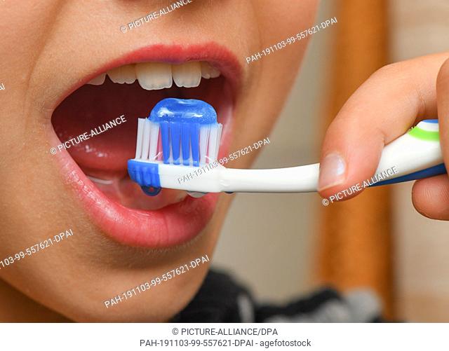 ILLUSTRATION - 02 November 2019, Brandenburg, Sieversdorf: A nine-year-old girl brushes her teeth with toothpaste. Berlin experts for dental health reach almost...