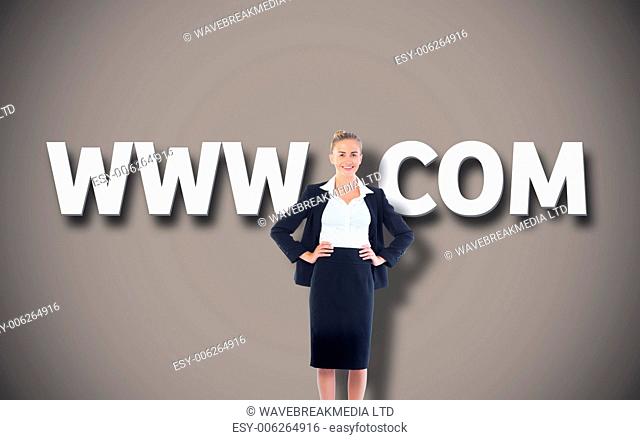 Businesswoman standing with hands on hips against grey background with vignette