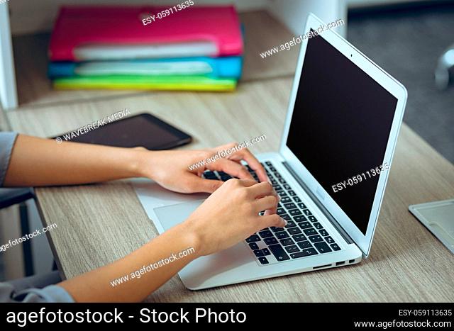 Mixed race businesswoman sitting at desk using laptop having video call