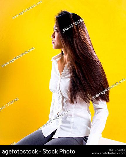 Young Asian woman - portrait shot against yellow background - studio photography