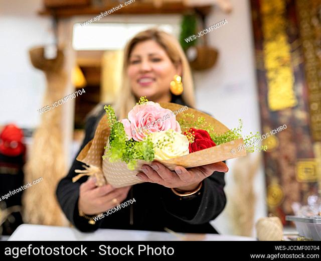 Florist holding bouquet at flower shop