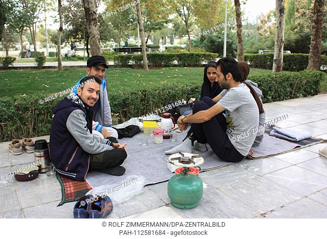 Iran - Teenagers picnicking in a park near the 33-arch bridge on the Zayandeh Rud River in Isfahan (Esfahan), capital of the province of the same name