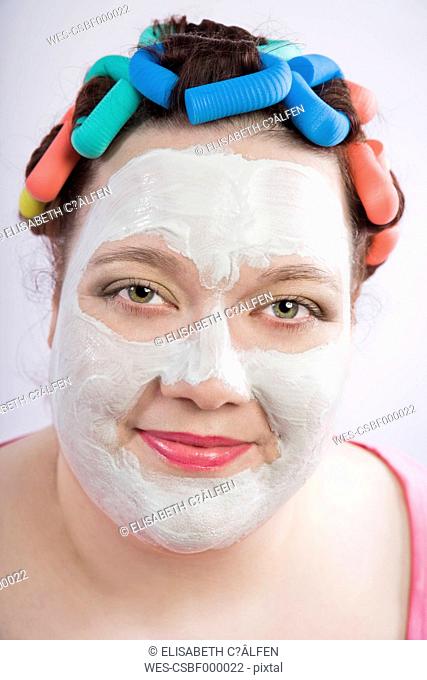 Portrait of woman wearing beauty mask and curlers