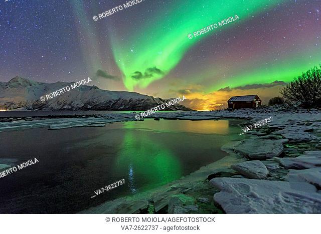 The Northern Lights illuminates the icy landscape in Svensby Lyngen Alps Tromsø Lapland Norway Europe
