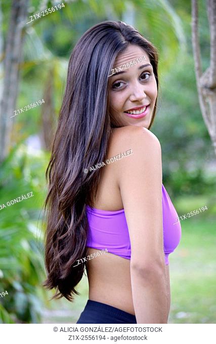 Latin woman in sport bra posing in park, casual gesture, Caracas, Venezuela
