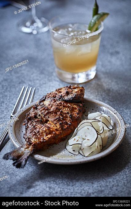 Indian spiced fried fish with an orange cocktail