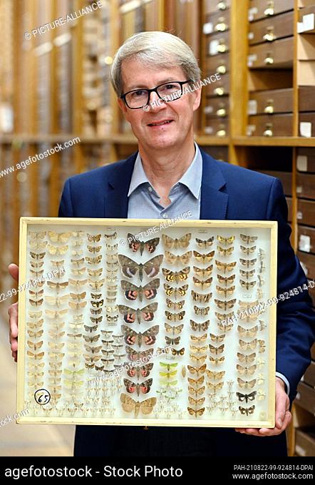 05 August 2021, Baden-Wuerttemberg, Karlsruhe: Norbert Lenz, director of the State Museum of Natural History Karlsruhe, shows a collection box with different...