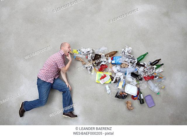 Young man vomiting garbage