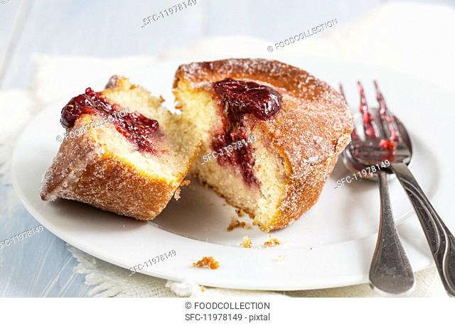 A doughnut muffin with raspberry jam, sliced