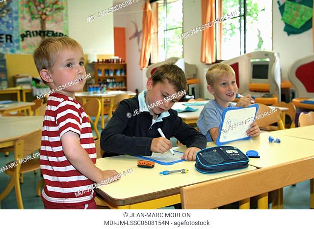 Three young boys studying in a classroom