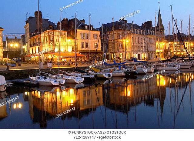 Night harbour scene with yachts and restaurant lights. Honfleur, Normandy, France