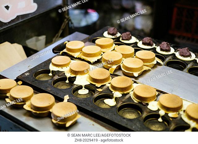 Traditional sweet red bean and cream cakes being made on a iron skillet mold in Taipei, Taiwan