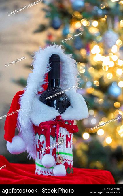 A red wine and bottle with blurred bokeh lights on Christmas tree in background. Christmas gift, Holiday, present concept with copy space Merry Christmas
