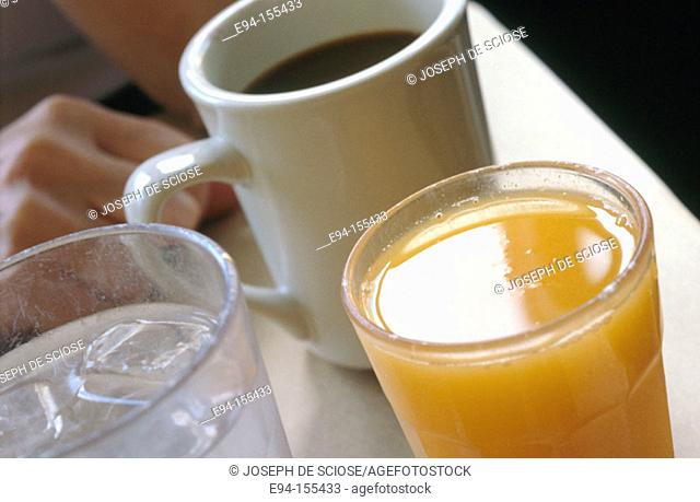 cup of coffee, glass of orange juice and water-close up