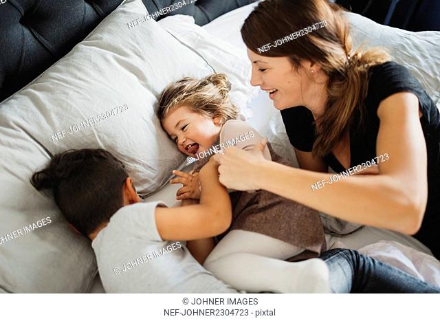 Mother and kids playing in bedroom