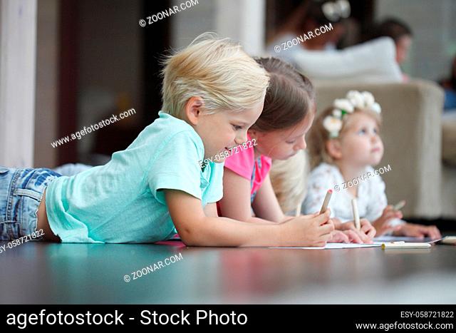 Group of cute children drawing with colorful pencils on floor