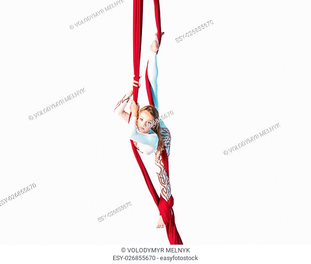 Graceful gymnast performing aerial exercise with red fabrics