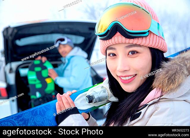 The young couple after the car carrying skis