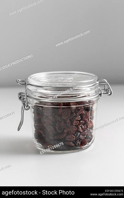 close up of jar with raisin on white table