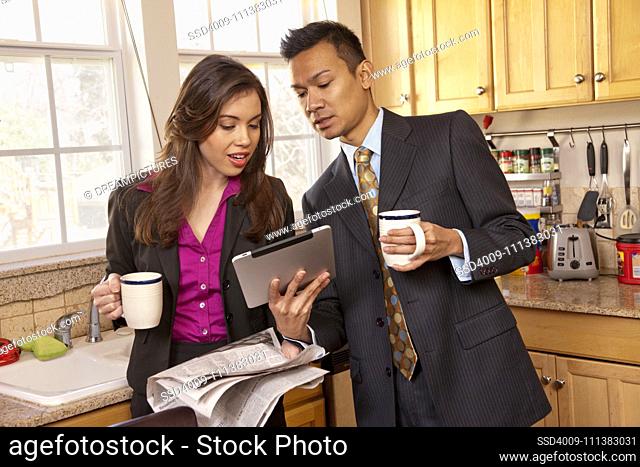 Couple looking at digital tablet in kitchen