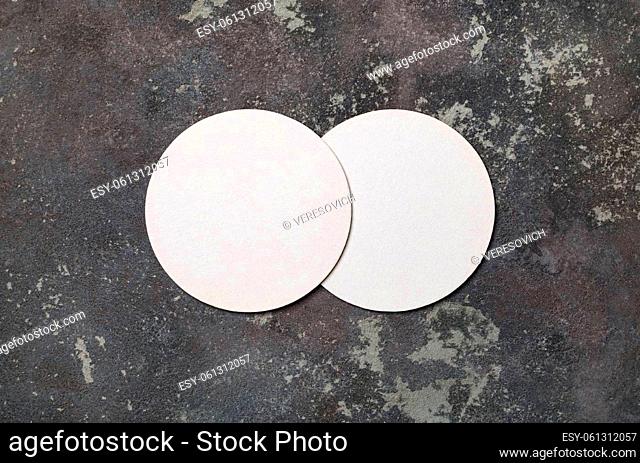 Blank white beer coasters on concrete background. Responsive design mockup. Flat lay