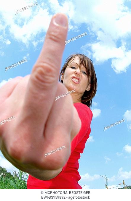 aggressive, young woman shows The finger