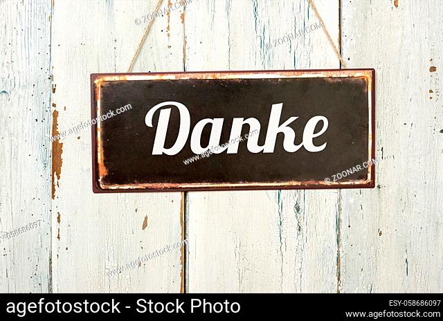 Old metal sign in front of a white wooden wall - Danke - German word for Thank you