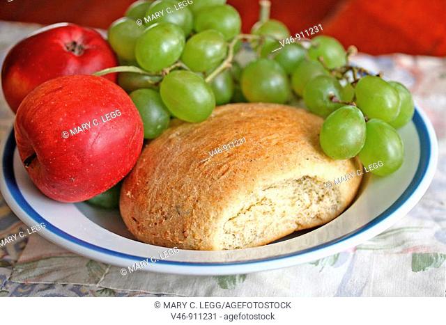 Bread, apples and grapes on plate  Home-baked broccoli bread with green grapes and red apples on plate  Whole grain wheat bread with broccoli  Very good  bread