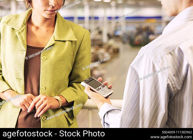 Businessman and businesswoman looking at cell phone