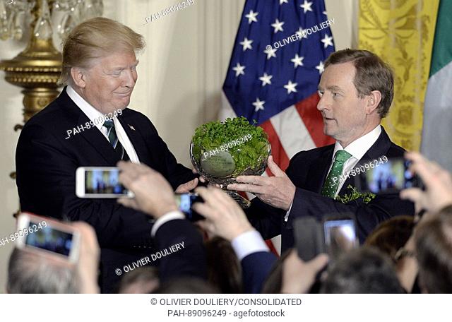 United States President Donald J. Trump, left, accepts a bowl of shamrocks from Prime Minister (Taoiseach) Enda Kenny of Ireland during a reception in the East...