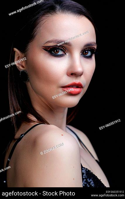 Beautiful young woman portrait with vogue shining face makeup. Eye shadows with golden sparcles