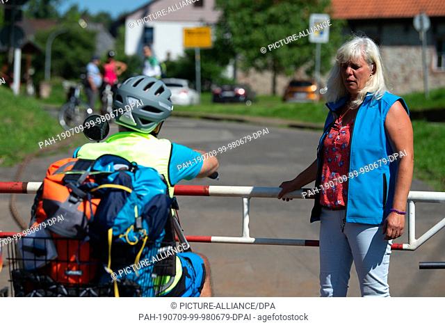 17 June 2019, Lower Saxony, Wahmbeck: Petra Helga Ilsenann, ferrywoman of the Weser ferry Wahmbeck, speaks to a passenger on the yaw rope ferry