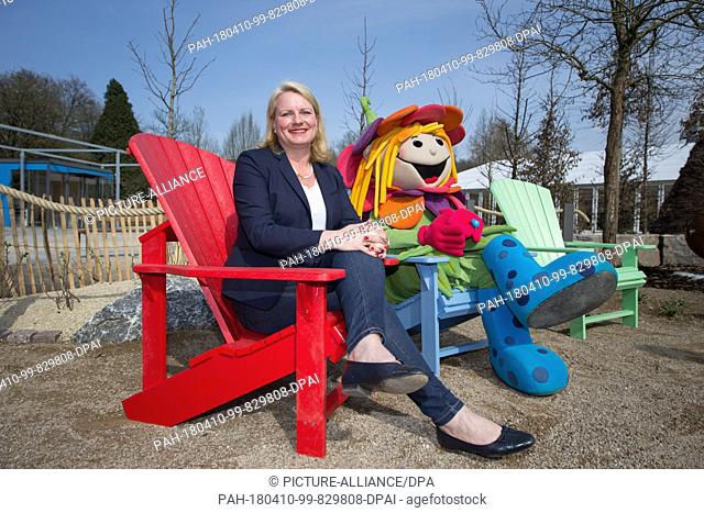 10 April 2018, Germany, Bad Iburg: Ursula Stecker, director of the National Garden Show, and the gardening exhibit's mascot Rosalotta sit on chairs on the...