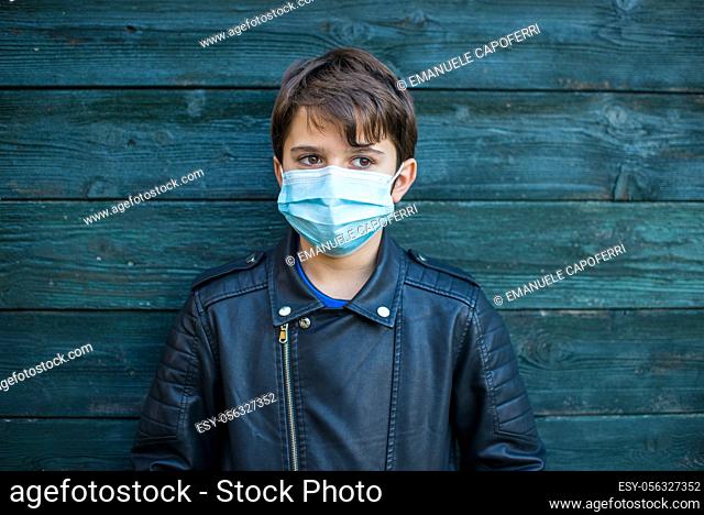 portrait of 11 year old child with mask for covid, sad look