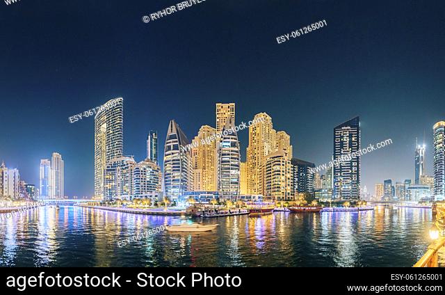 Dubai Marina Port, UAE, United Arab Emirates - Beautiful Night view of high-rise buildings of residential district in Dubai Marina And Tourist Boat
