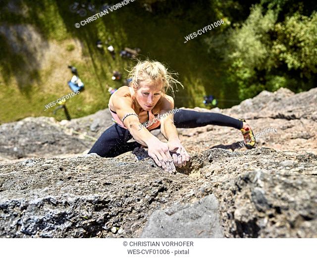 Austria, Innsbruck, Hoettingen quarry, woman climbing in rock wall