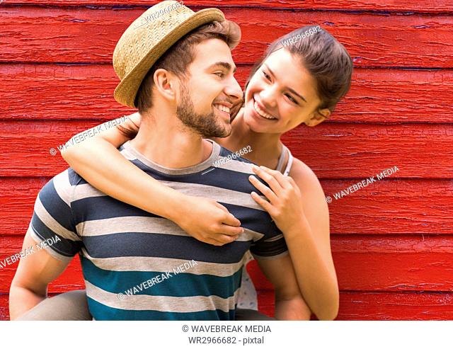young couple looking each other with red wood background
