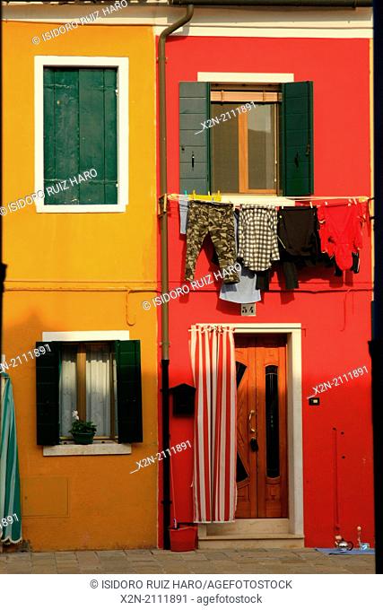 Washed clothes hanging and Colored buildings. Burano. Venice. Veneto. Italy