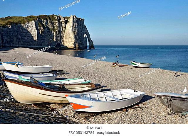 Small fishing boats on the famous pebble beach and cliffs of Etretat, commune in the Seine-Maritime department in the Haute-Normandie region in northwestern...