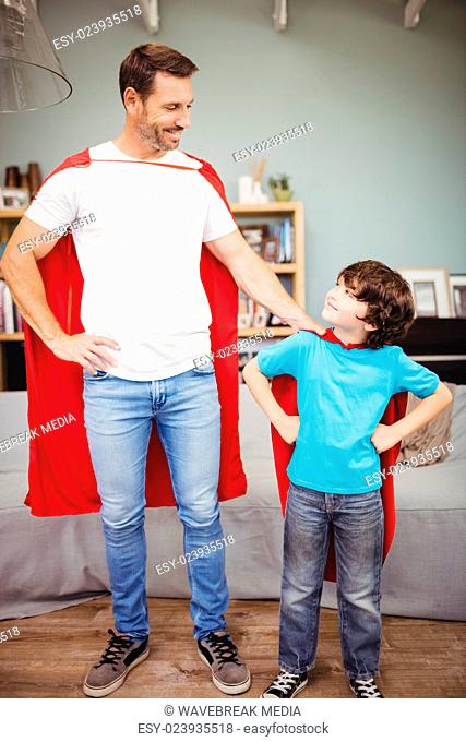 Happy father and son in superhero costume