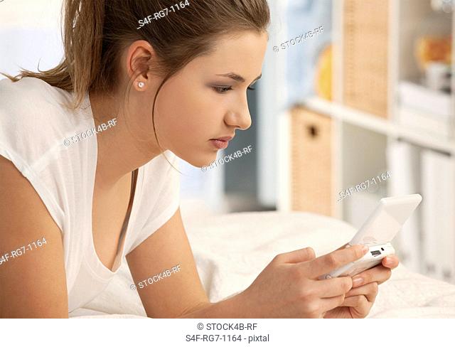 Teenage girl using handheld game console