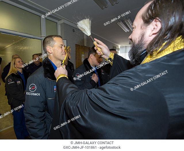 Expedition 3435 Flight Engineer Tom Marshburn of NASA, left, receives the traditional blessing from a Russian Orthodox priest at the Cosmonaut Hotel on the...