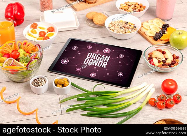 ORGAN DONOR concept in tablet pc with healthy food around, top view
