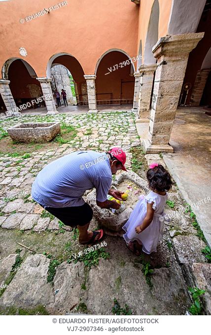 Father & daughter collecting fruits in the Interior of the convent of Mama, Yucatan (Mexico)