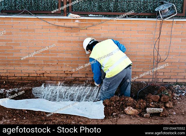 Worker working with pneumatic hammer on a construction site