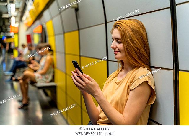 Woman using smartphone in underground station
